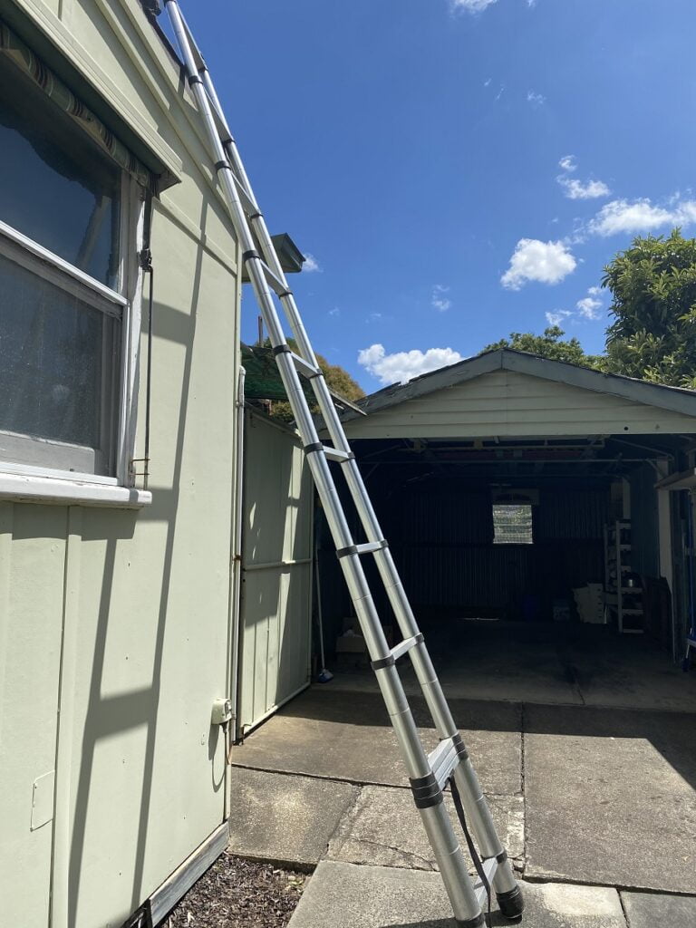 Telescopic ladder leaning against a house